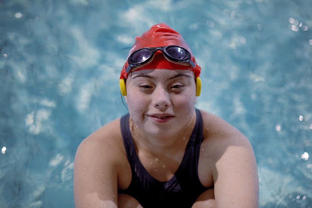 Young woman wearing a red swimming cap in a swimming pool