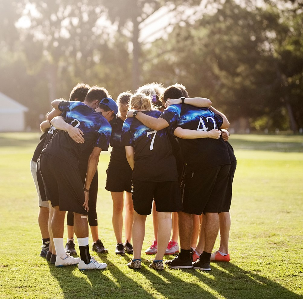 Team huddle in a green field
